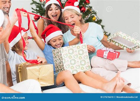 Happy Family At Christmas Opening Gifts Together Stock Photo - Image: 27676610