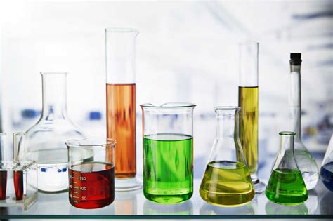 Beakers of various solutions on shelf in lab stock photo