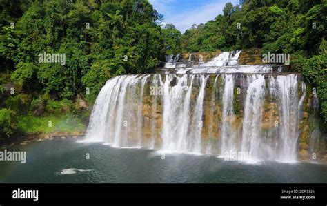 Cascade of Tinuy-an Falls in green forest, aerial drone. Waterfall in the tropical mountain ...