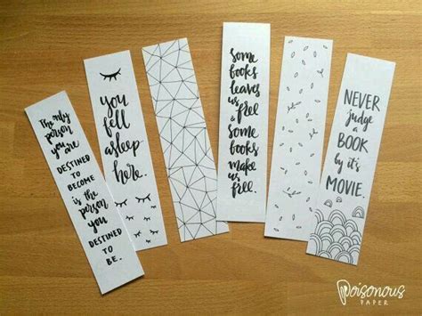 five bookmarks with handwritten text on them sitting on a wooden table ...