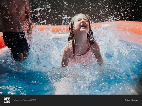 Kids splashing in inflatable pool stock photo - OFFSET