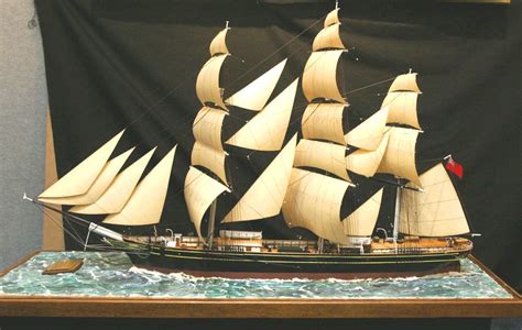 a model sailboat on display in front of a black backdrop