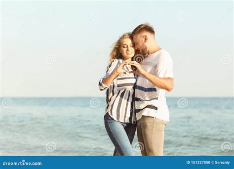 Cute Young Couple Making Heart with Their Hands on Sea Shore Stock Photo - Image of coast, love ...