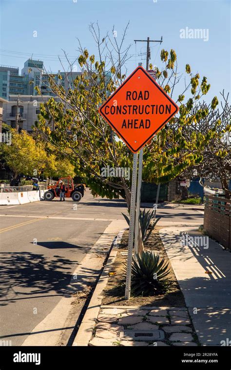 Image of a bright orange road construction ahead sign Stock Photo - Alamy