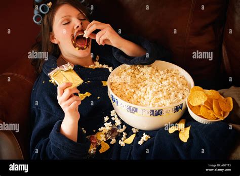 Woman eating junk food Stock Photo - Alamy