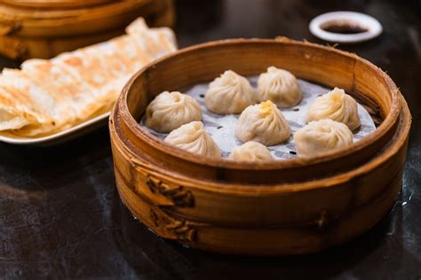 Premium Photo | Steamed xiao long bao (soup dumplings) in the bamboo basket. served in ...