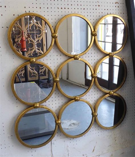 MIRRORED WALL ART, with nine circular mirrors in a gilded frame, 68cm x ...