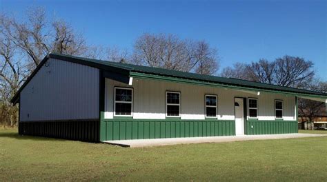 a small green and white building sitting on top of a lush green grass covered field