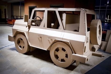 the vehicle is made out of cardboard and has wheels on each side, as well