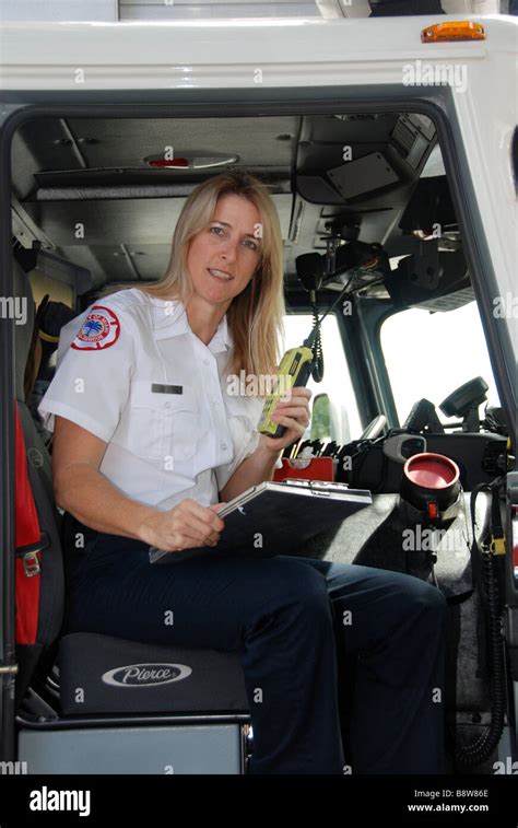 Female firefighter paramedic EMT in dress uniform looking at camera ...