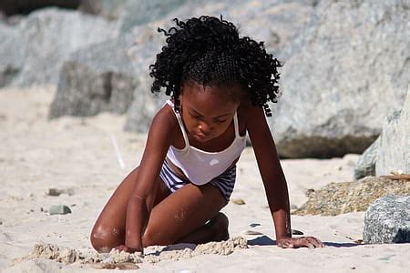 Royalty-Free photo: Smiling Child in Black Dress Shirt Walking on Brown Sand during Daytime ...