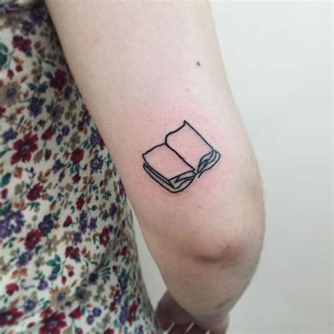 Open book tattoo by Suki Lune inked above the right elbow | Open book tattoo, Minimal tattoo ...