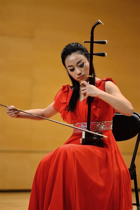 a woman in a red dress is playing the violin