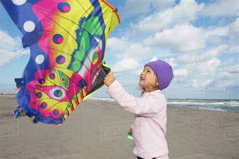 Girl flying kite on beach - Stock Photo - Dissolve