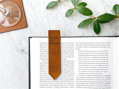 an open book sitting on top of a table next to a leafy green plant