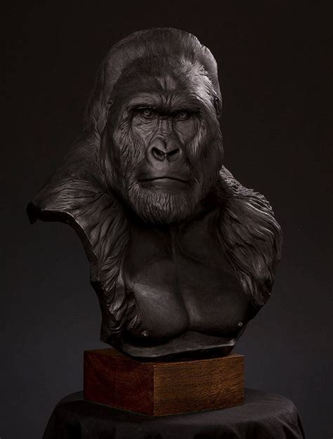 a statue of a gorilla head on top of a wooden block in front of a black ...