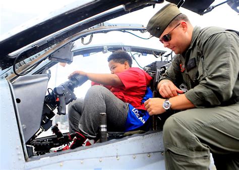 A child sits inside the cockpit of an AH-1W Super Cobra - NARA & DVIDS ...