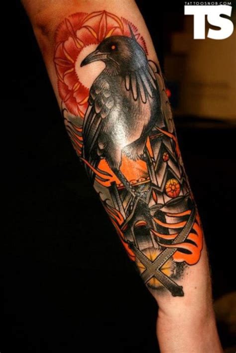 Old school colorful forearm tattoo of crow with burning city ...