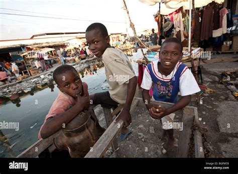 Boys sit along an open drainage canal in Gonaives, Artibonite ...