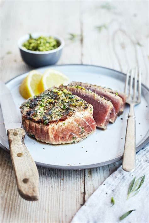 Herb and Garlic Grilled Tuna Steaks with lemon on a platter with fork ...