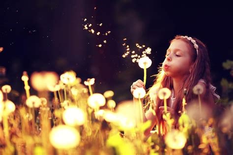 Premium Photo | Girl blowing a dandelion seeds flying