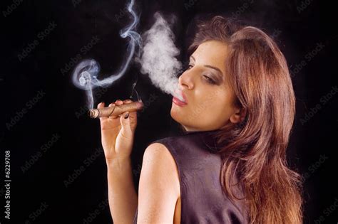 Young beautiful woman blowing smoke rings from cigar Stock Photo ...