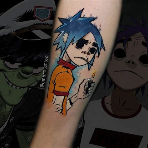 Na imagem um braço com uma tatuagem do personagem 2D da banda gorillaz toda em colorido, no ...