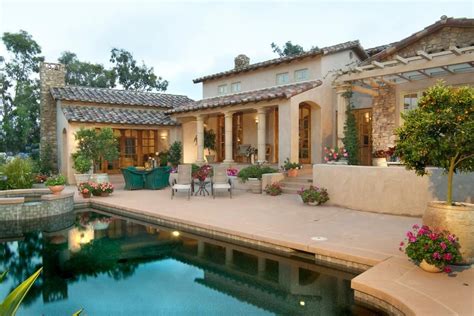 This Mediterranean-inspired home seamlessly blends the indoors and out with rustic French doors ...