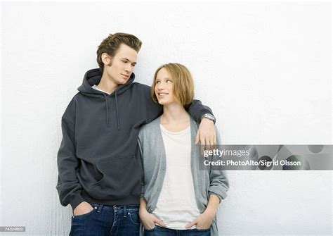 Young Couple Man With Arm Around Womans Shoulder Woman Looking Up At Him High-Res Stock Photo ...