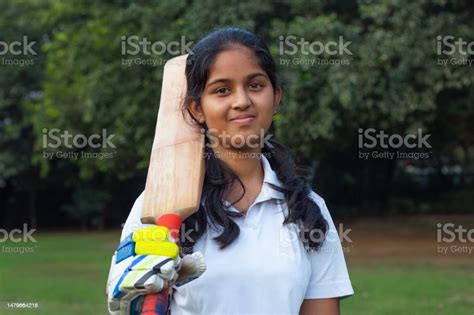 Portrait Of A Female Cricketer Holding A Cricket Bat Stock Photo - Download Image Now - iStock