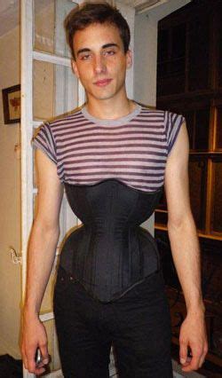 a man wearing a corset standing in front of a window with his hands on ...