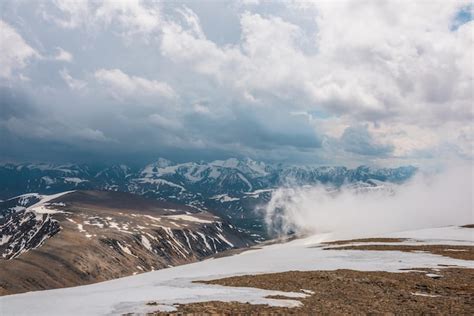 Premium Photo | Awesome top view through clouds to high snowy mountains ...