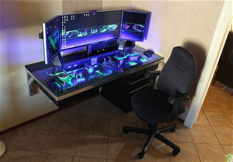 there is a desk with two monitors and a keyboard on it, next to a chair