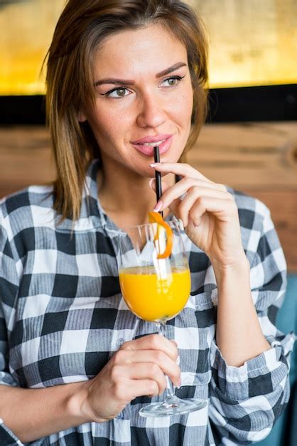 Premium Photo | Beautiful young woman drinking orange juice