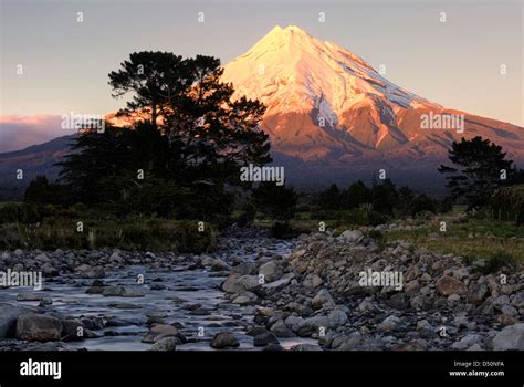 Mount Taranaki at sunrise with river in foreground. Taranaki, New ...