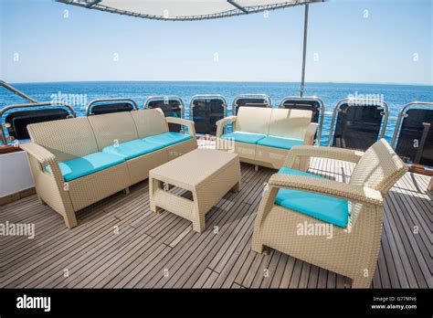 Rear teak deck of a large luxury motor yacht with chairs sofa table ...