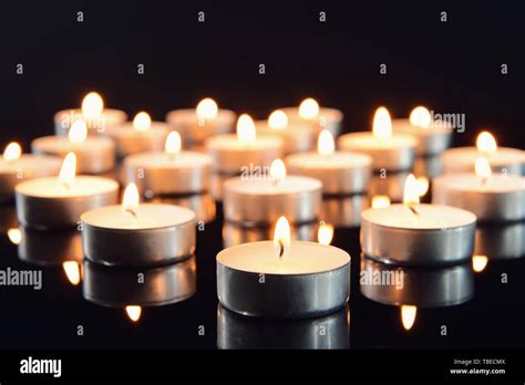 Many burning candles as symbol of mourning on dark background Stock Photo - Alamy