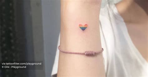 Rainbow heart tattoo located on the wrist.