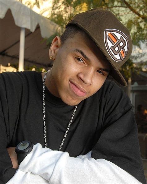 a young man wearing a brown hat and black shirt