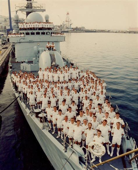 a large group of men in white uniforms on a boat