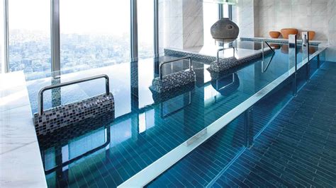 an indoor swimming pool with blue tiles and chairs around the edge in ...