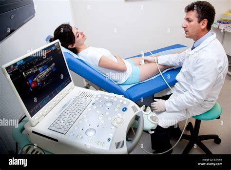 Woman undergoing a Doppler ultrasound (angiodynography) scan of the ...