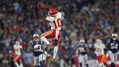 Tyreek Hill Is Jumping High To Catch A Ball Wearing White Red Sports ...