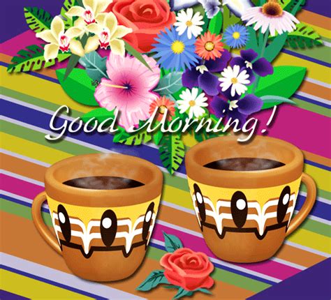 two coffee cups sitting next to each other on top of a striped table cloth with flowers