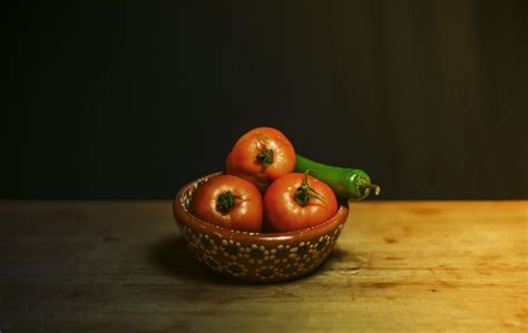 Red Tomatoes and Green Chili on Brown and White Floral Ceramic Bowl on Brown Wooden Table · Free ...