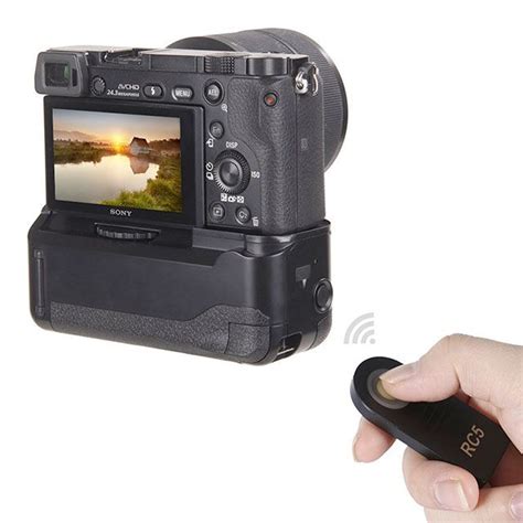 a hand holding a camera with a mouse in front of it