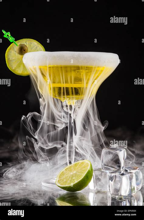 Martini drink with dry ice smoke effect, served on glass table with ...