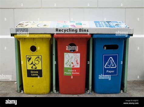 Three colour coded plastic recycling bins for aluminium drink cans ...