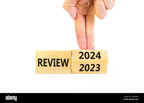 2024 review new year symbol. Businessman turns a wooden cube and changes words Review 2023 to ...