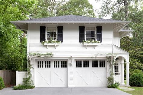 Gorgeous home exterior boasts a traditional two car garage framed by white siding and positioned ...